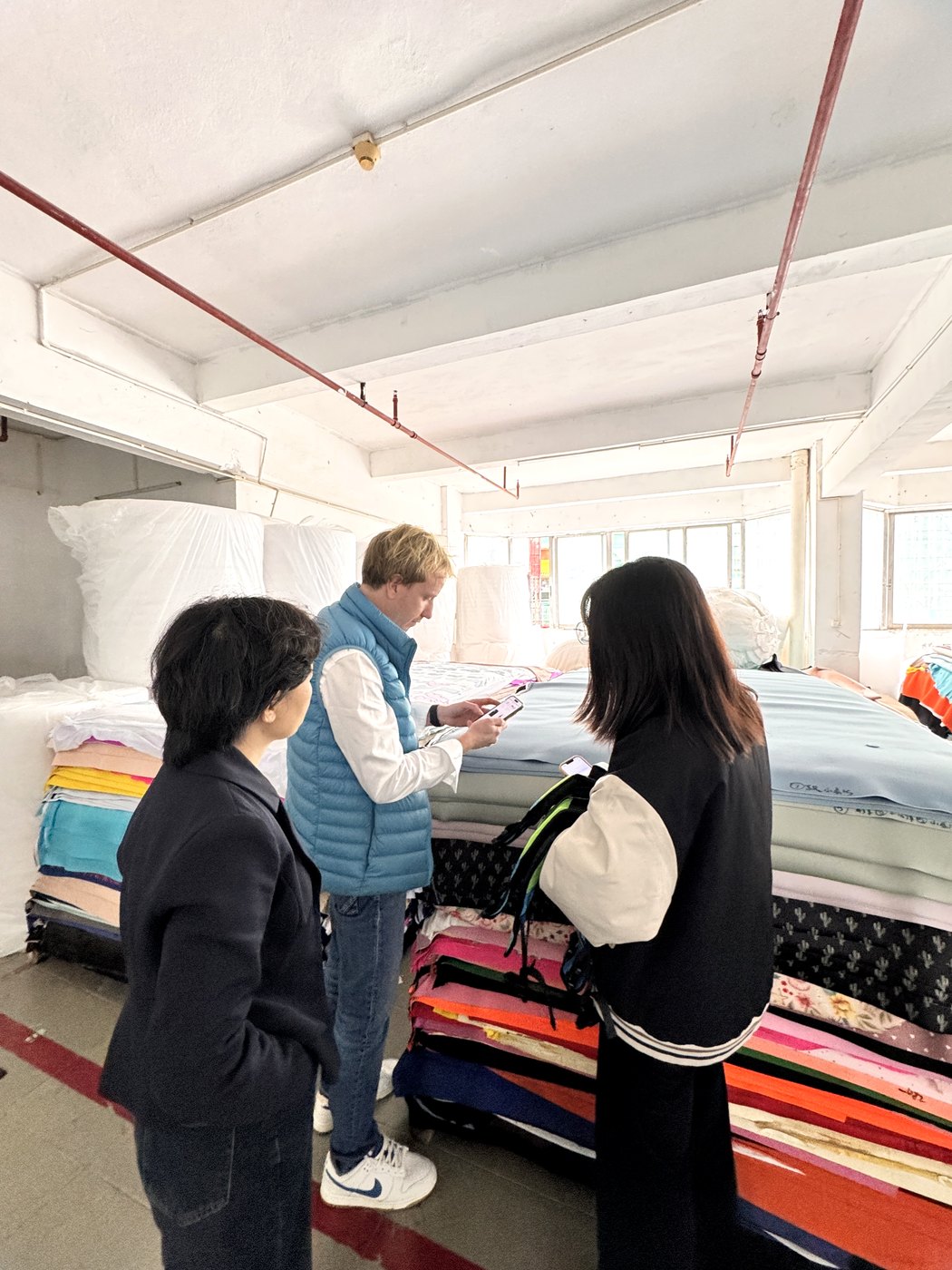 Customer visiting Huatop material area to review neoprene fabric colors